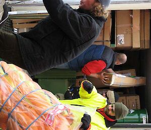 Expeditioners handling cargo from container on ship