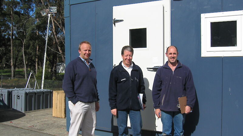 Builders and engineer pose in front of ablutions module