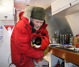 Gary holding an emperor penguin in work van