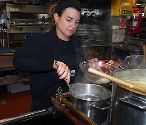 Chef standing over a steaming pot.