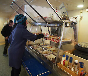 Expeditioner helping themselves to salads from a buffet.