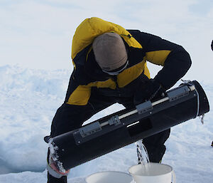 Person in cold weather gear lifting equipment and tipping it out…