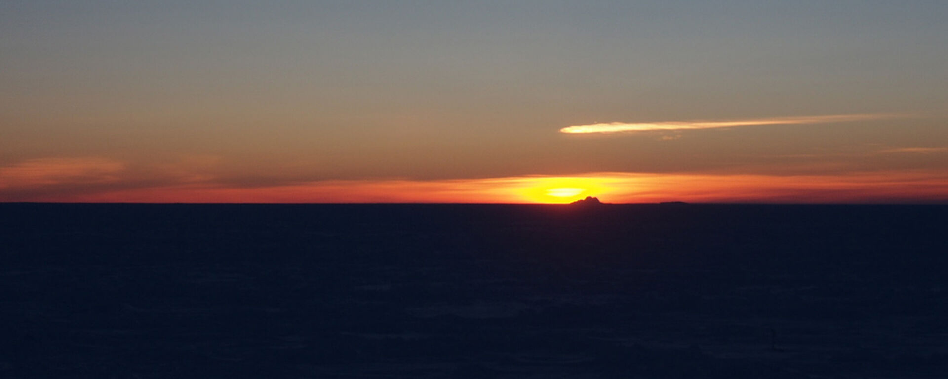 Dark clouds with an orange sun sinking