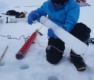 Ken uses a lasso to help remove ice core. Aurora Australis in the background