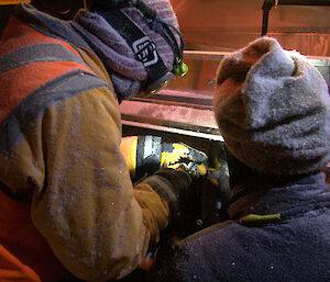 Rob King (left) and a science technical support team member make adjustments to the krill pump equipment in challenging Antarctic conditions (Photo: Kym Newbery)