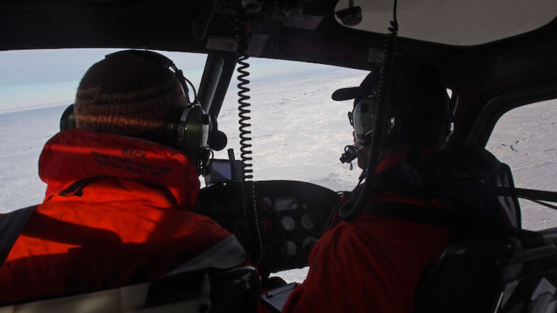 Voyage Chief Scientist Dr Klaus Meiners (left) and pilot Doug Grey look for an ice floe for the first scientific transect (Photo: Wendy Pyper)