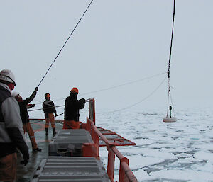 An accelerometer is deployed from a crane over the side of the ship (Photo: Brett Free)