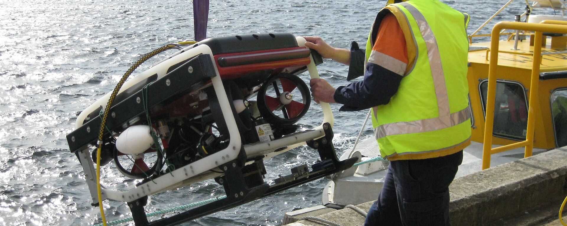 The ROV being lowered by a crane into the Derwent River.