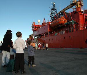 People looking at the ship docked at the wharf