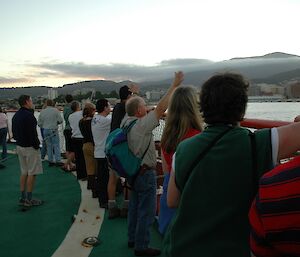 Group of expeditioners on deck waving goodbye