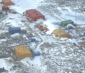 Aerial view of Casey station showing brightly coloured buildings in the snow