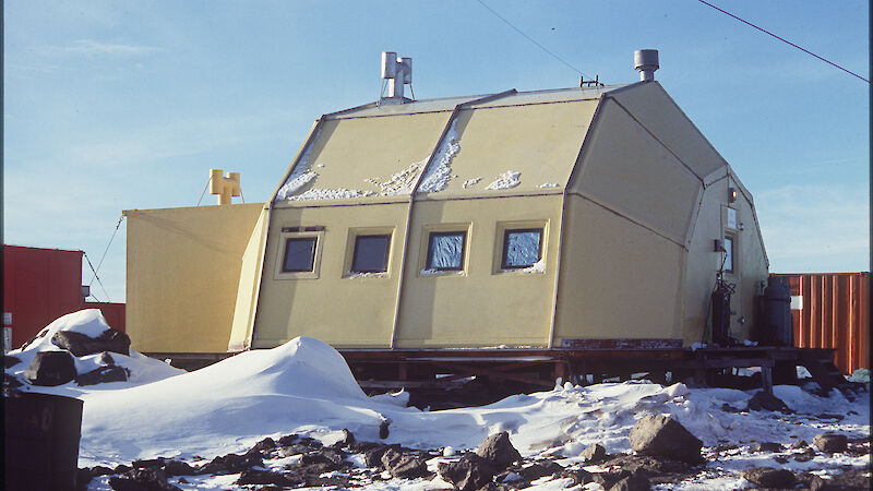 A small yellow building with a distinctive shape.