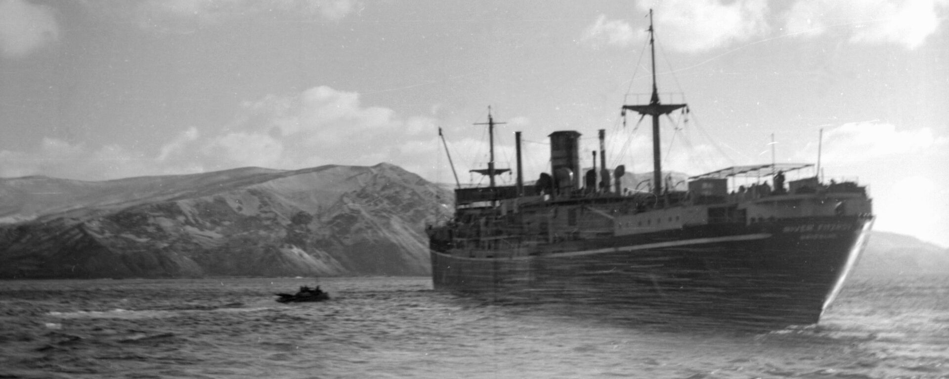Black and white image of ship at anchor of coast