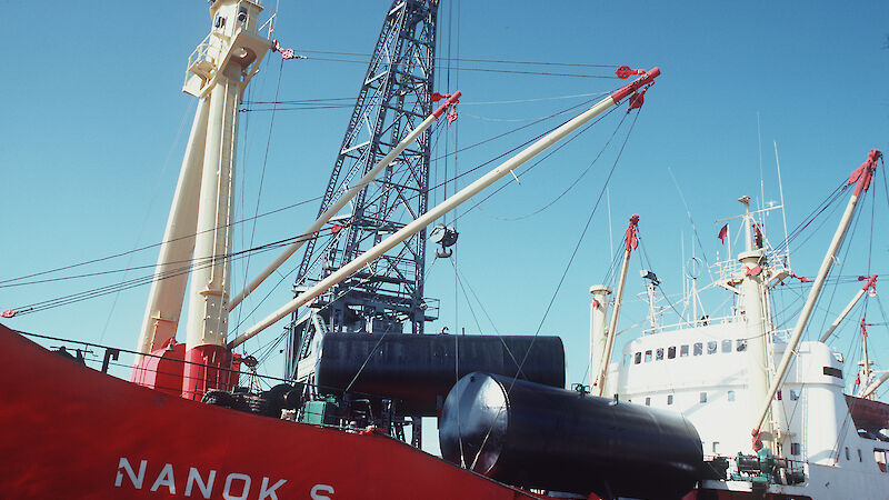 A ship with cranes against a blue sky.