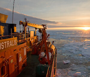 Aurora Australis in the ice, with sunset in the background.