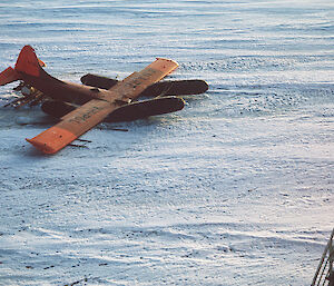 An orange plane sinking into the ice.