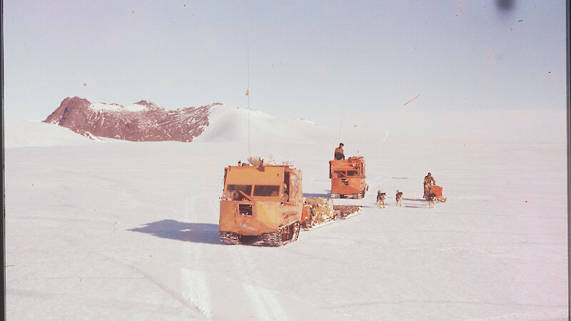 Oversnow vehicles and dogs on the ice during traverse