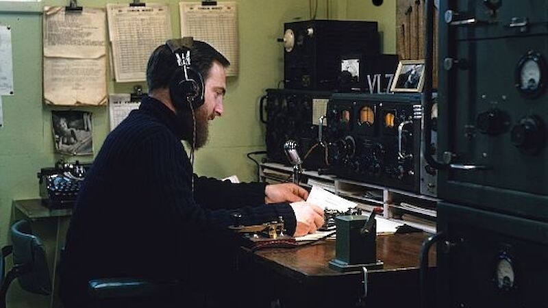 Older style colour photo of a radio operator at the set