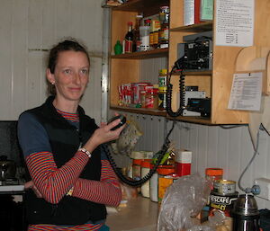 Expeditioner using the VHF radio in a field hut.