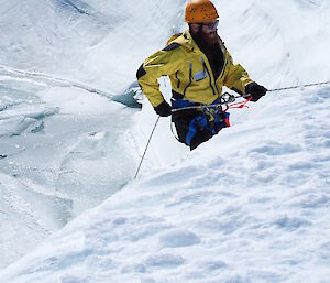 Expeditioner abseiling down ice bank