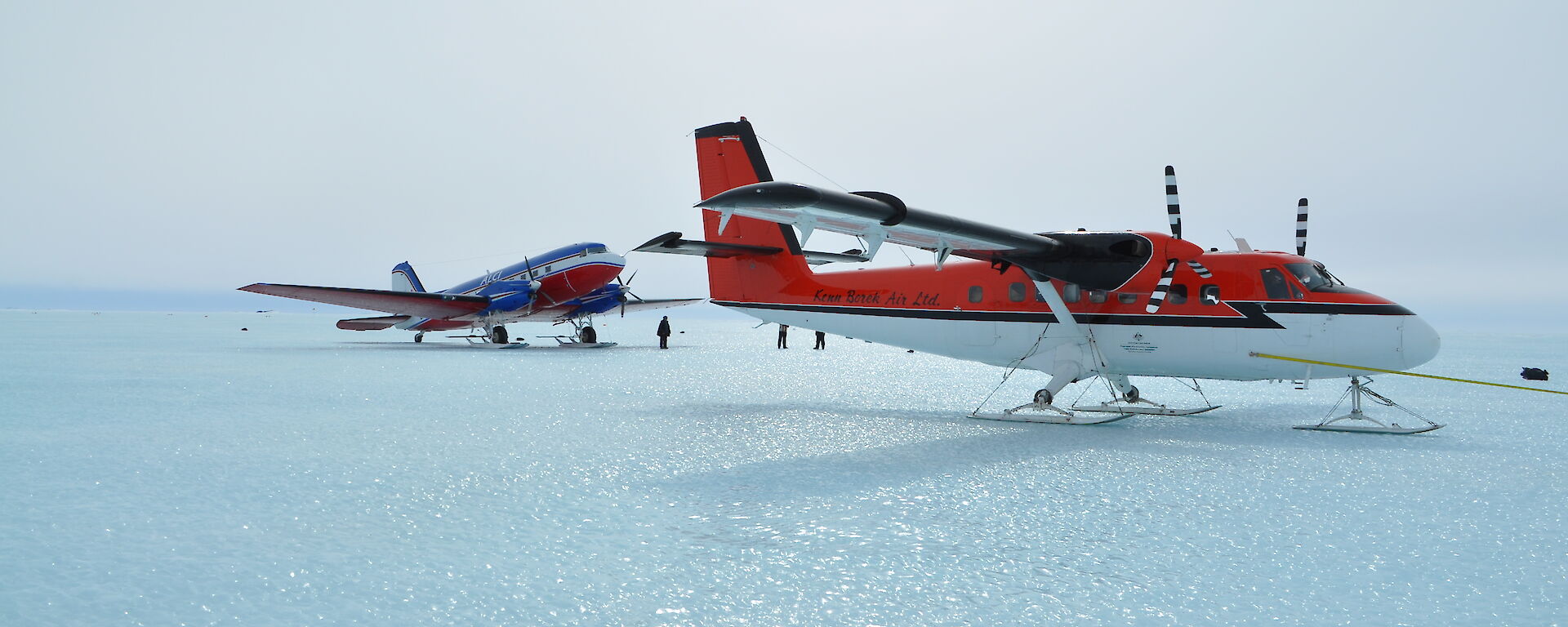 Two planes, the Basler just larger than the Twin Otter, parked next to each other.