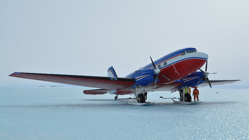 The Basler, painted red and white, is stationary on the ice.