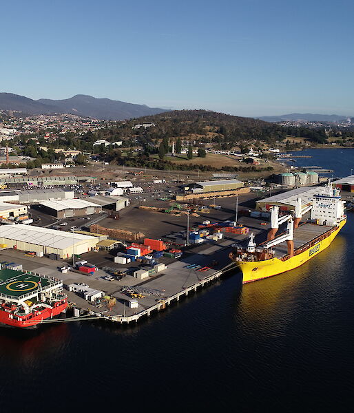 An aerial drone photo of three ships in the port of a city.