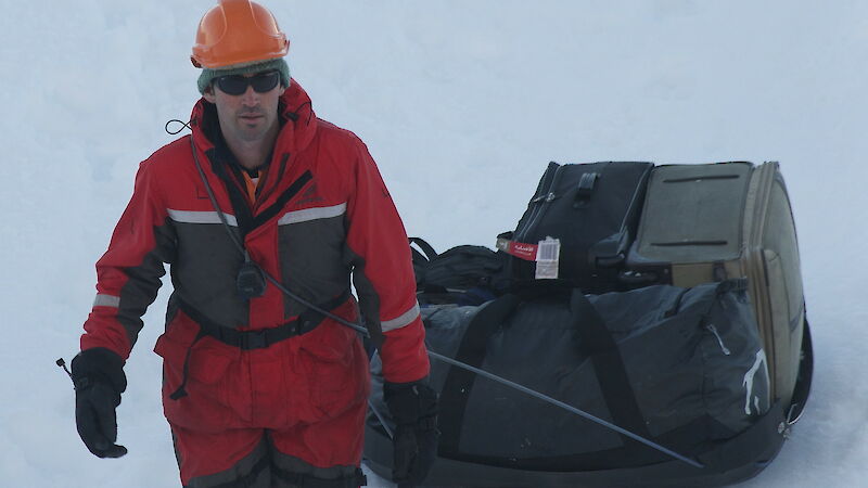 Field team member bringing luggage to the ship.