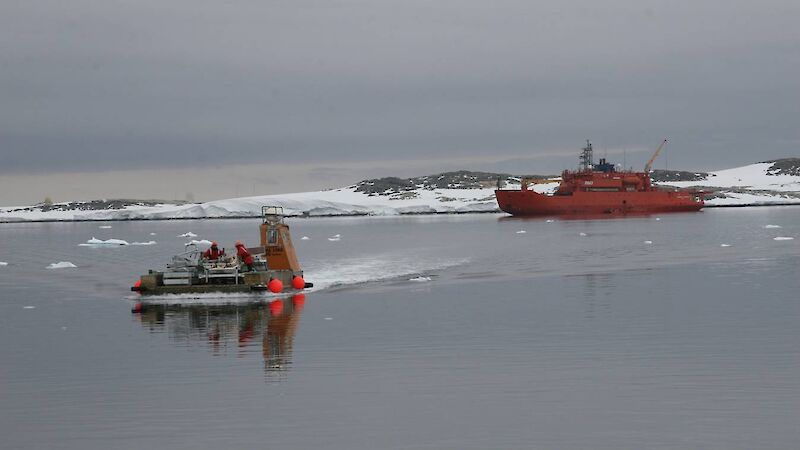 A barge motoring away from the ship.