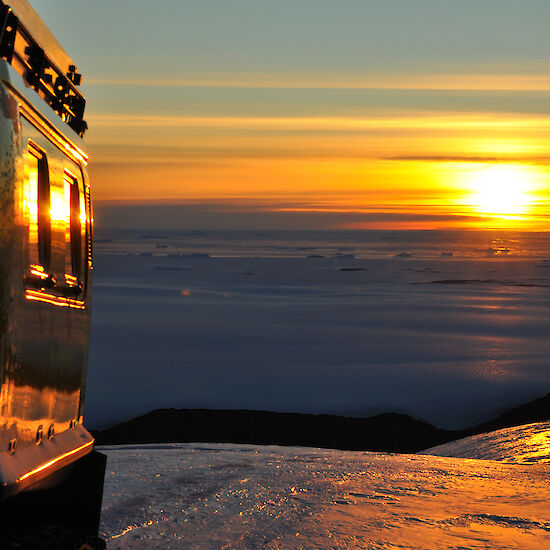 Beautiful colours of sunset reflecting off sea ice, plateau ice and hagglund at the same time