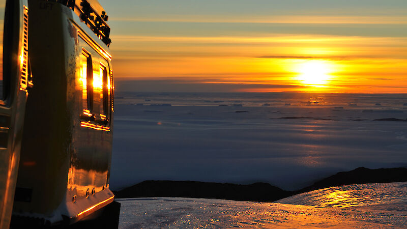 Beautiful colours of sunset reflecting off sea ice, plateau ice and hagglund at the same time