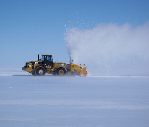 Large tracked vehicle clears snow on runway