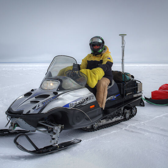 Reed Burgette riding the snowmobile equipped with GPS for surveying.