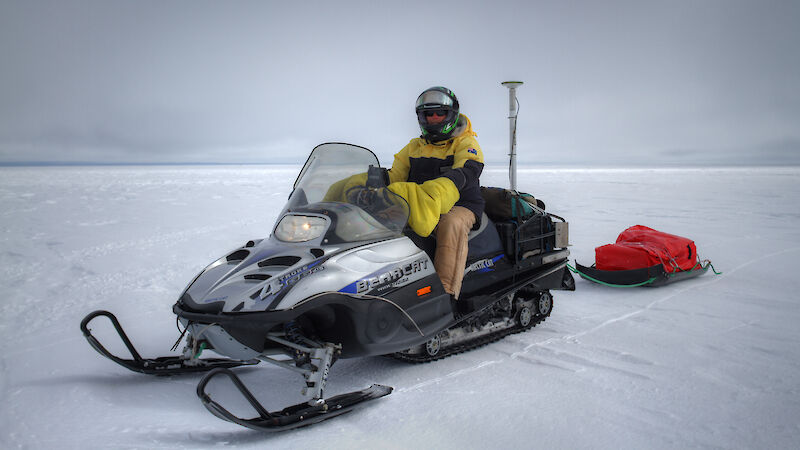 Reed Burgette riding the snowmobile equipped with GPS for surveying.