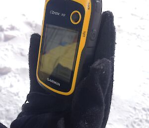 Close up of hand holding a small GPS unit
