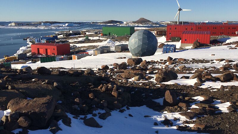 Mawson station looking east over station buildings to distant small islands, on bright sunny day