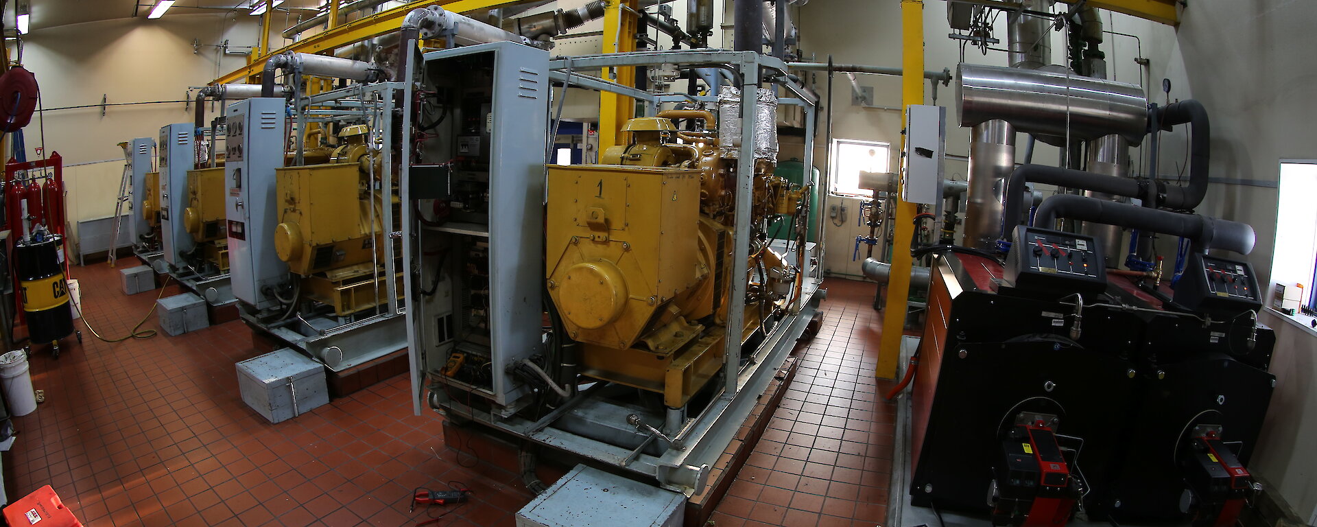 The engine room of the main power house. Rows of large diesel engines.