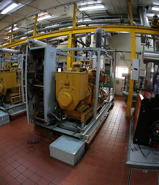 The engine room of the main power house. Rows of large diesel engines.