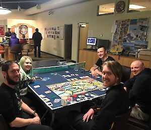 Expeditioners sitting at table playing board game