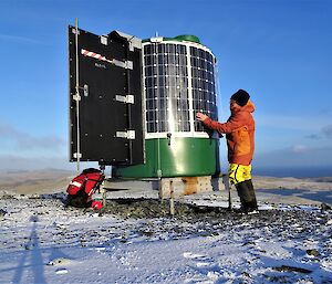Expeditioner checking solar panels on repeater hut