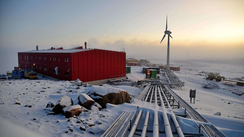 Sea fog moving in at station with the red vehicle workshop on left and wind turbine in centre