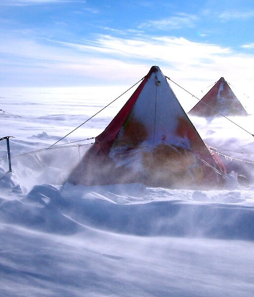 Snow blows around a tent.