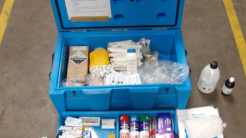 Esky containing bottles of chemicals, gloves and items to deal with a spill.