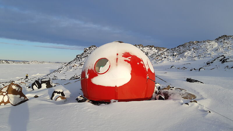 Apple field hut with snow on it.