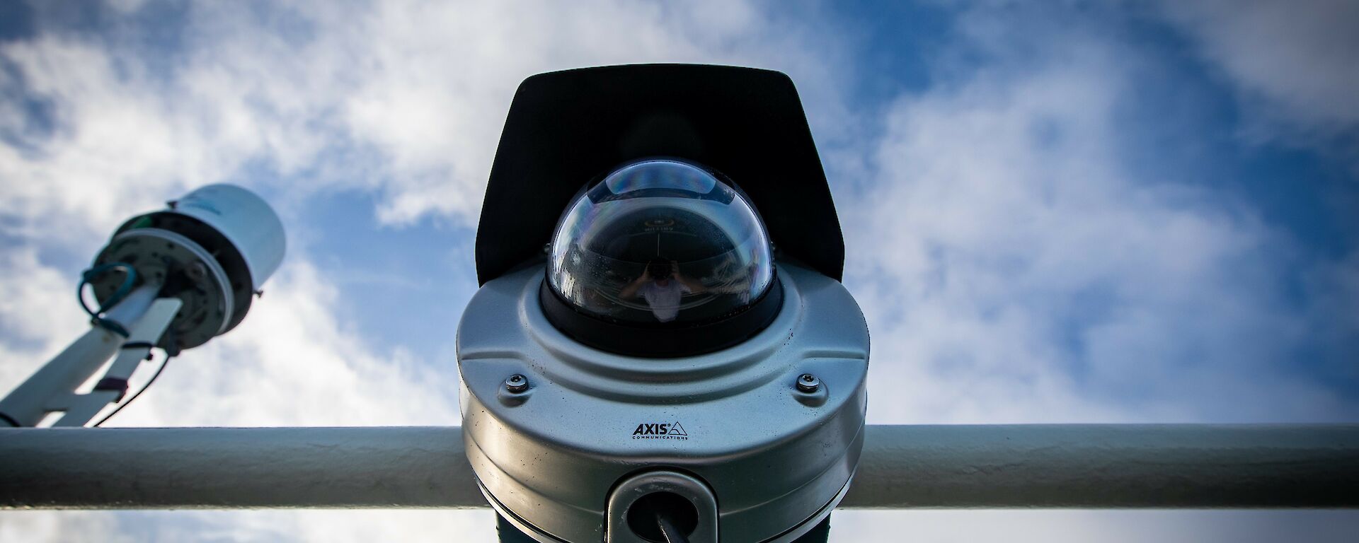 View of the webcam from below, showing the cylindrical camera body with hemispherical glass lens cover.