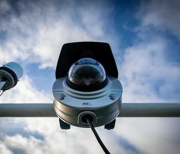 View of the webcam from below, showing the cylindrical camera body with hemispherical glass lens cover.