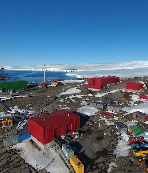 Low aerial view over Mawson station buildings.