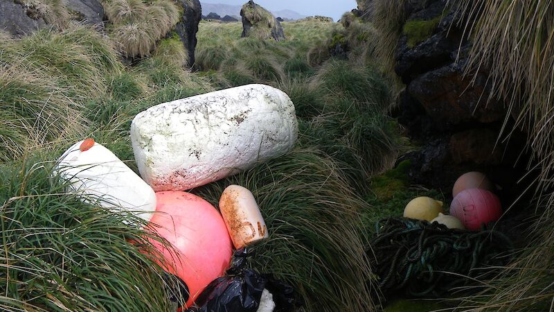 Debris stash at Unity Point, consisting of several different coloured fishing floats, black plastic bags filled with smaller pieces of rubbish and a large block of styrofoam — still to be collected