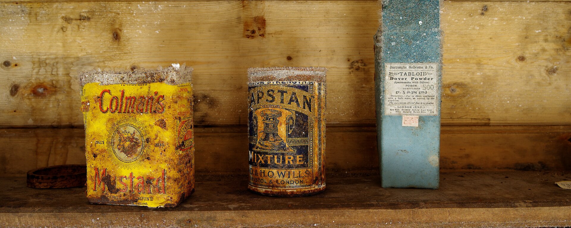 A row of tins on a shelf, covered in ice crystals.