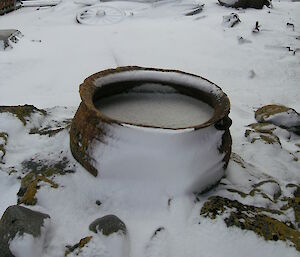 A snow covered iron pot